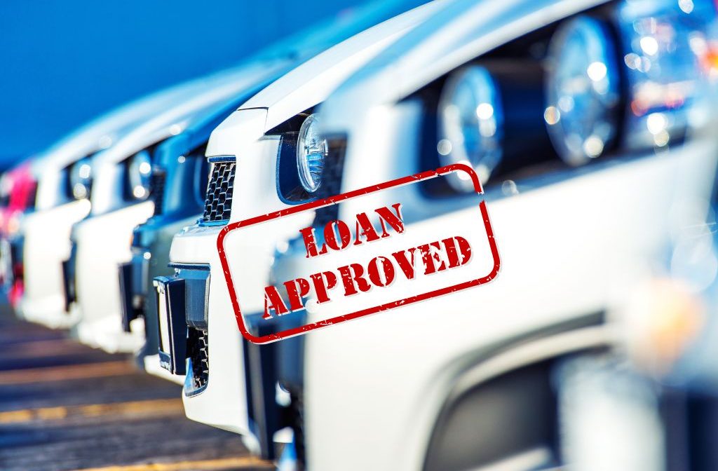 A lineup of new cars with a bold red "Loan Approved" stamp, signifying successful auto loan applications.