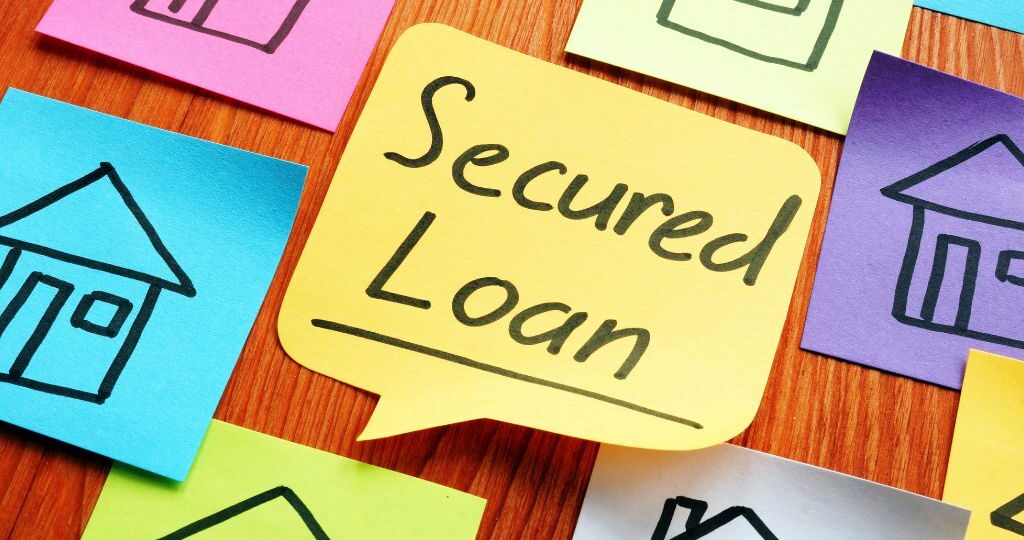 Colorful sticky notes with house illustrations and a central note labeled "Secured Loan," representing mortgage or secured loan concepts.