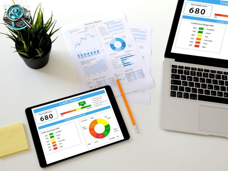 A tablet and a laptop displaying credit score reports with financial documents and a pencil on a white desk, representing financial analysis and credit assessment.